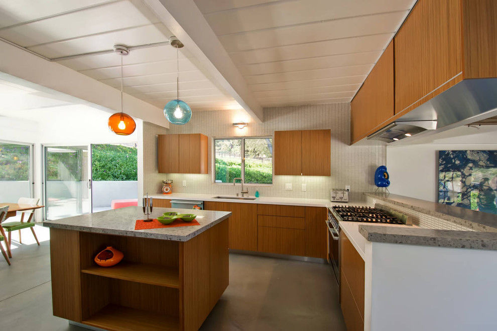 Design ideas for a modern l-shaped eat-in kitchen in San Diego with flat-panel cabinets, medium wood cabinets, white splashback and stainless steel appliances.