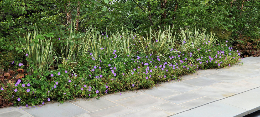 Traditional backyard garden in New York with natural stone pavers.