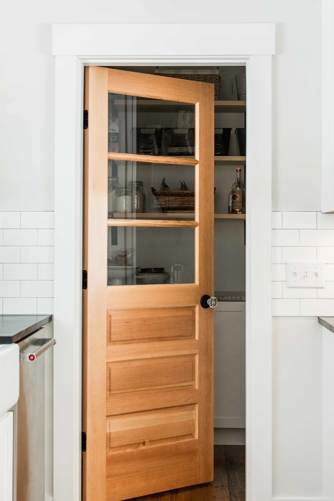 Design ideas for a mid-sized country l-shaped kitchen pantry in Portland Maine with shaker cabinets, white cabinets, soapstone benchtops, white splashback, subway tile splashback, stainless steel appliances, medium hardwood floors and brown floor.