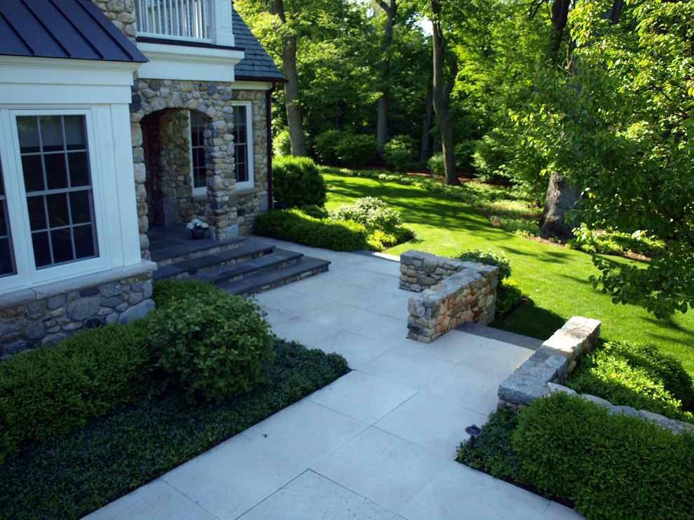 Expansive traditional backyard patio in Chicago with natural stone pavers and no cover.