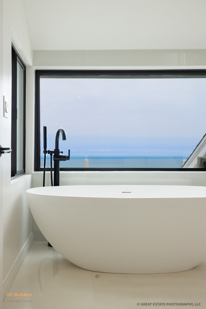 Пример оригинального дизайна: большая главная ванная комната в стиле модернизм с плоскими фасадами, черными фасадами, отдельно стоящей ванной, душем без бортиков, унитазом-моноблоком, разноцветной плиткой, белыми стенами, полом из керамогранита, накладной раковиной, мраморной столешницей, белым полом, открытым душем, белой столешницей, нишей, тумбой под две раковины, подвесной тумбой и сводчатым потолком