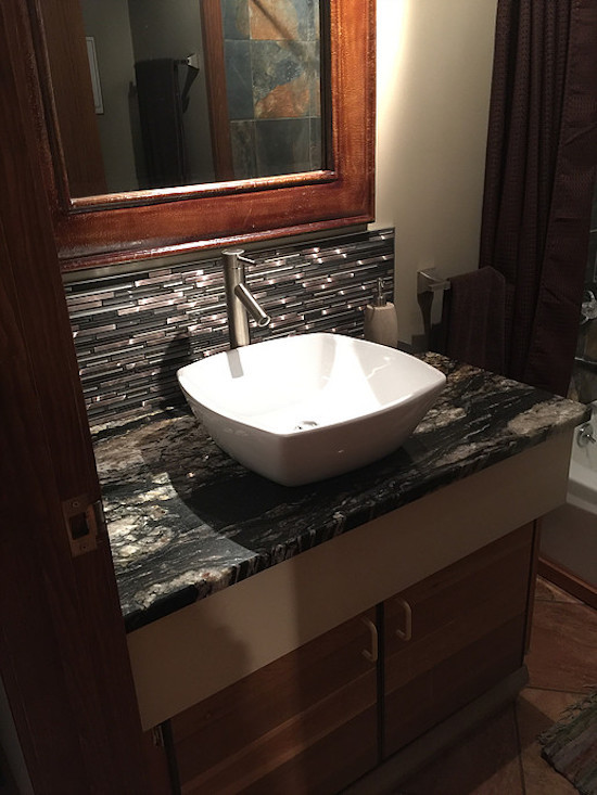 Inspiration for a mid-sized transitional 3/4 tub/shower combo remodel in Phoenix with flat-panel cabinets, light wood cabinets, beige walls, a vessel sink and marble countertops