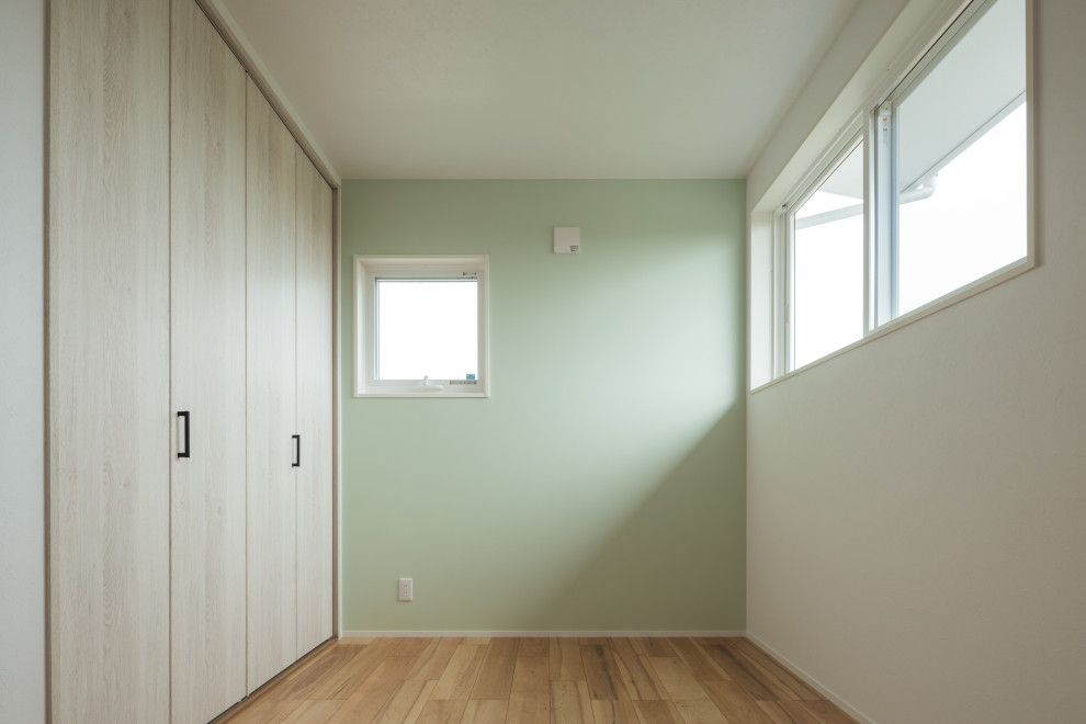 Inspiration för små könsneutrala barnrum kombinerat med sovrum, med vita väggar, ljust trägolv och beiget golv