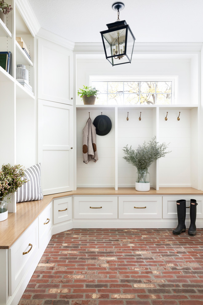 Photo of a country mudroom in Minneapolis with white walls, brick floors and multi-coloured floor.