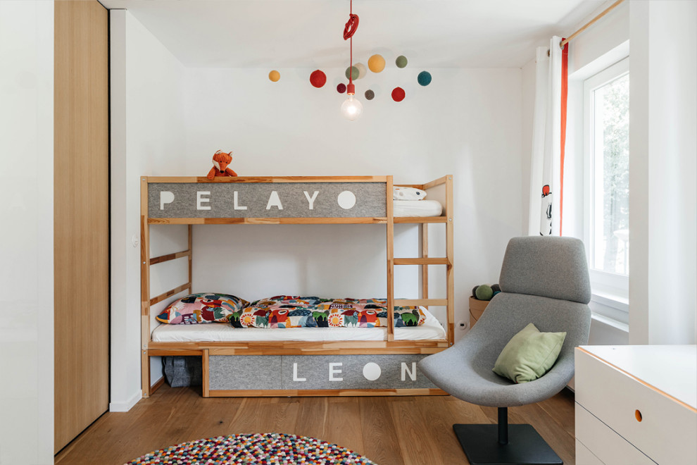 Design ideas for a contemporary kids' room in Other with white walls, medium hardwood floors and brown floor.