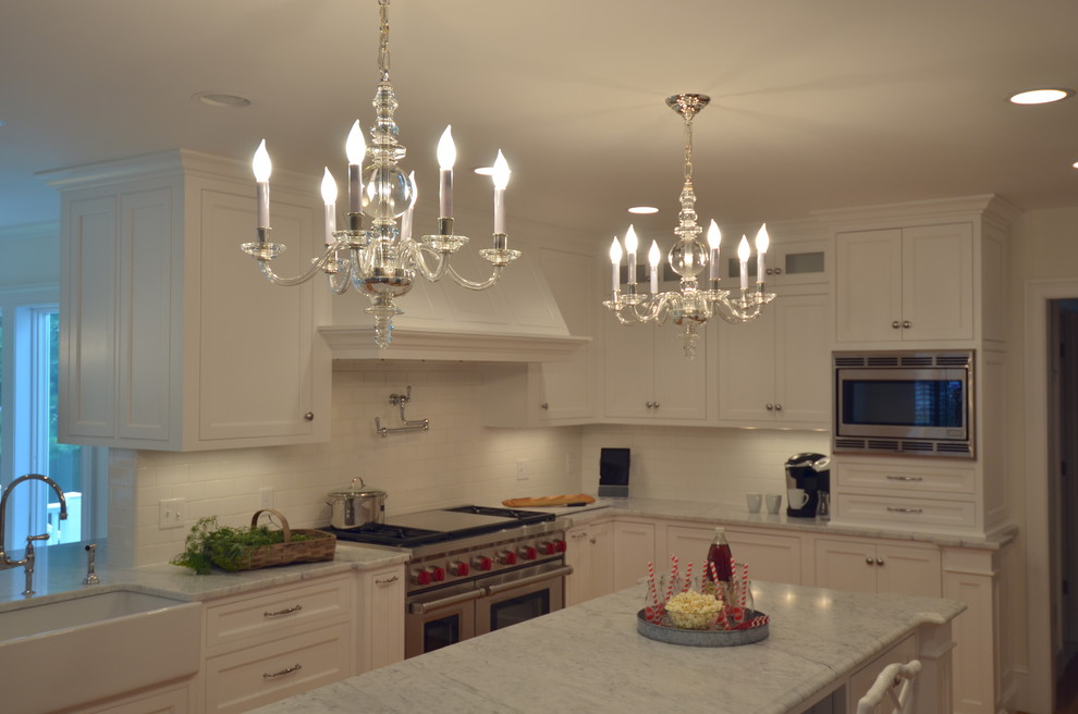 Transitional u-shaped medium tone wood floor eat-in kitchen photo in Boston with a farmhouse sink, beaded inset cabinets, white cabinets, marble countertops, white backsplash, subway tile backsplash, stainless steel appliances and an island
