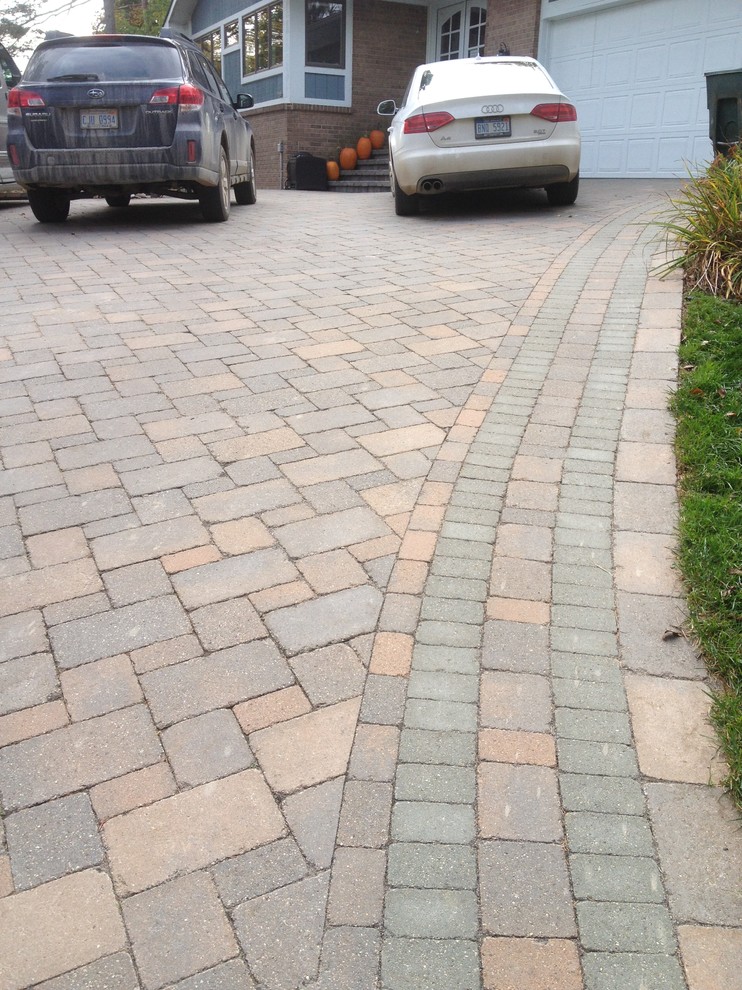 Design ideas for a large country front yard shaded driveway for fall in Detroit with brick pavers.