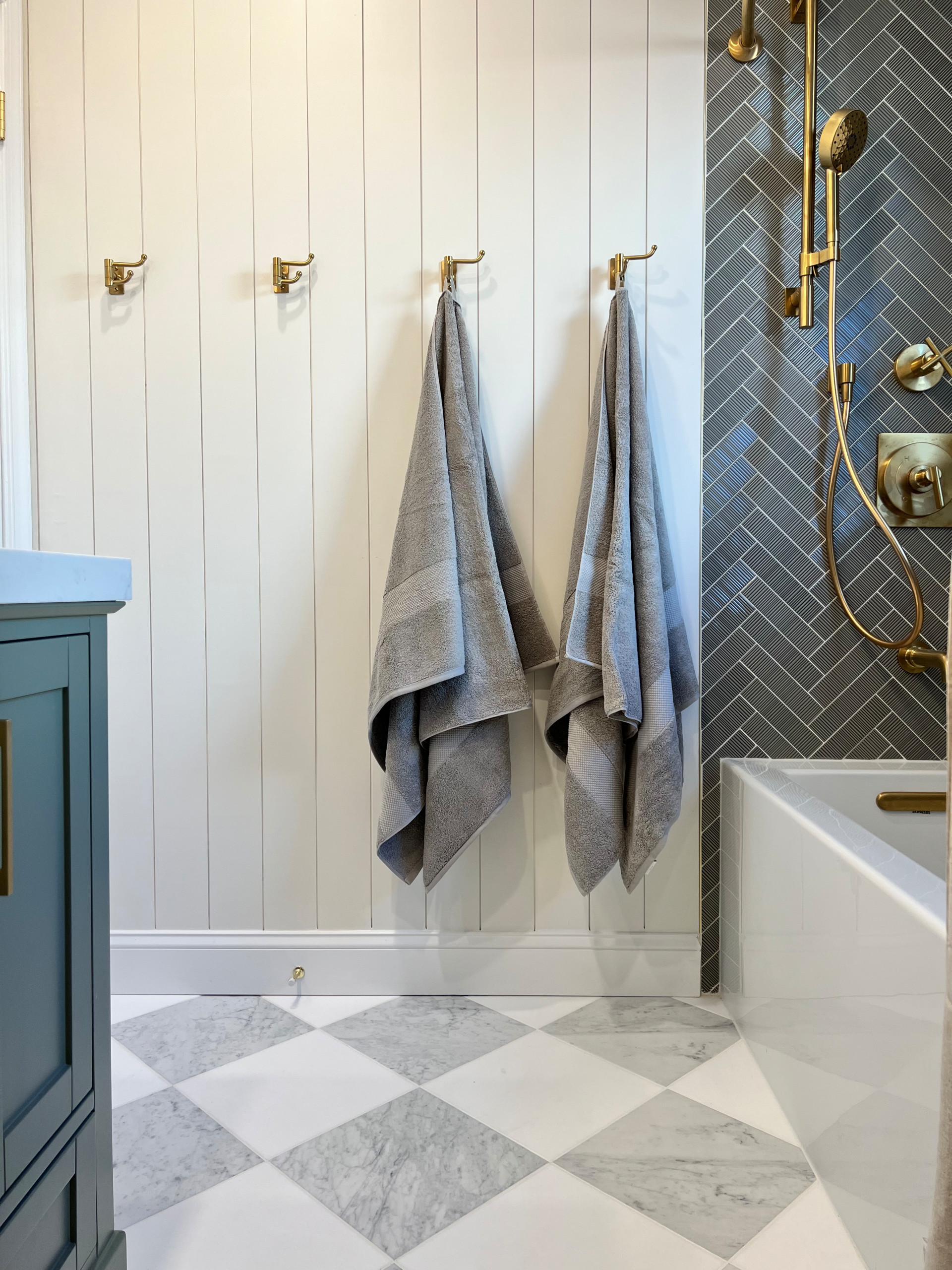 Transitional Primary Bathroom Renovation with herringbone ribbed tile, double vanity sink, and checkered flooring.