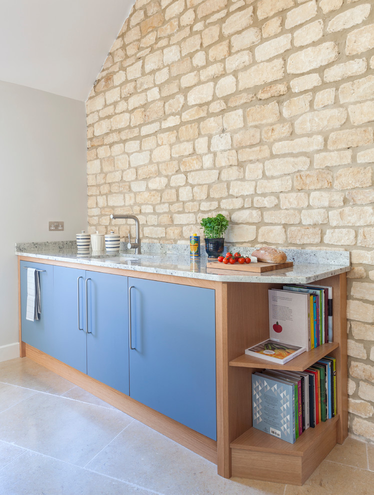 Inspiration for a mid-sized contemporary l-shaped eat-in kitchen in Wiltshire with a single-bowl sink, flat-panel cabinets, grey cabinets, granite benchtops, panelled appliances, limestone floors, with island and beige floor.