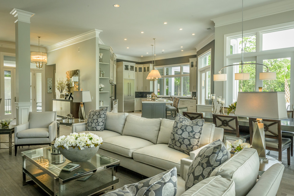 This is an example of a mid-sized contemporary open concept family room in Charleston with grey walls, porcelain floors, a standard fireplace, a built-in media wall, brown floor and a plaster fireplace surround.