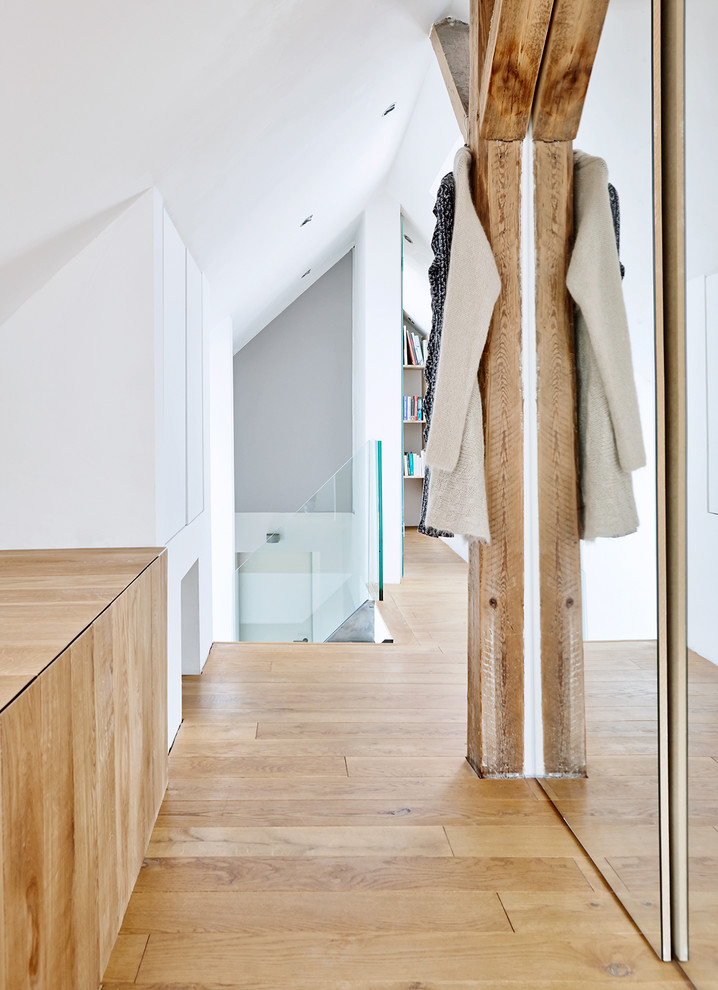 Photo of a mid-sized contemporary hallway in Hamburg with white walls and light hardwood floors.