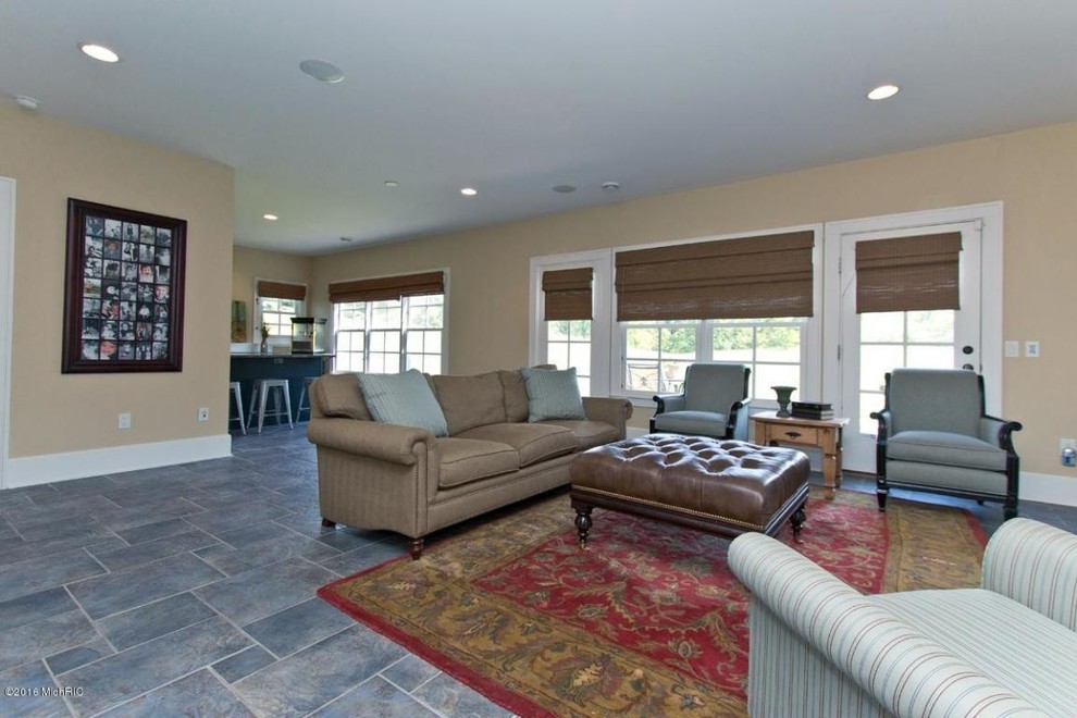 Large country open concept family room in Grand Rapids with a game room, slate floors and blue floor.