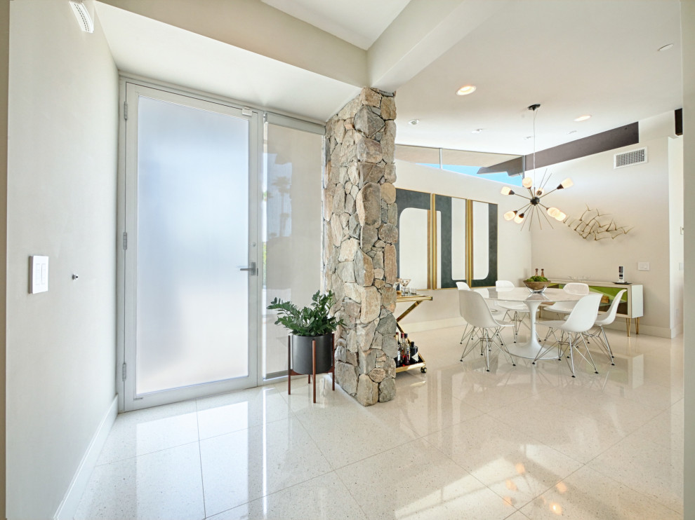 Ispirazione per un corridoio minimalista di medie dimensioni con pareti beige, pavimento in gres porcellanato, una porta singola, una porta in vetro e pavimento bianco