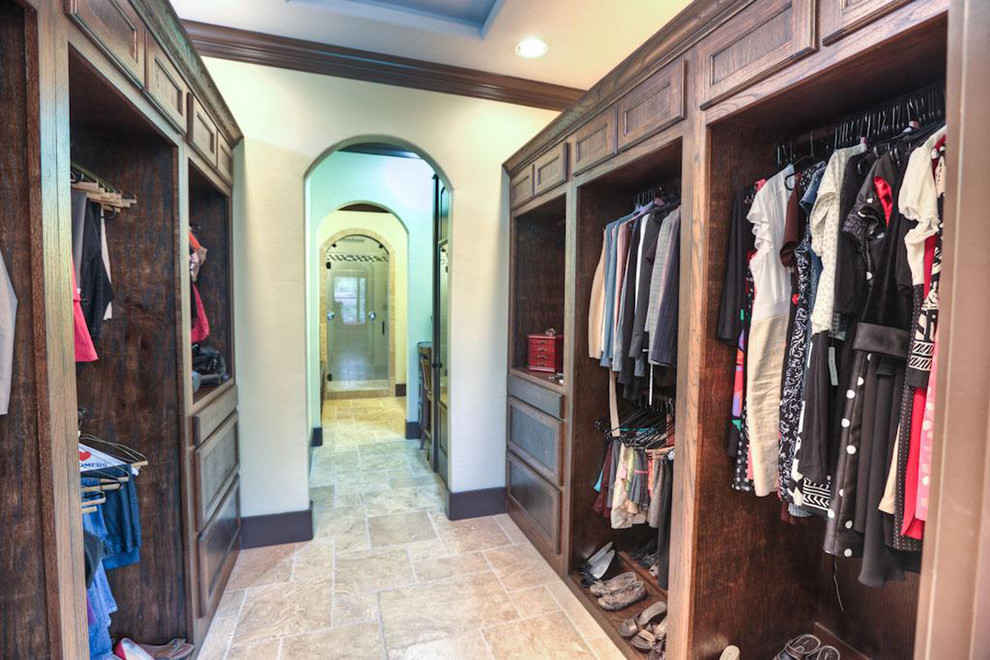 Inspiration for a mid-sized contemporary gender-neutral dressing room in Houston with open cabinets, dark wood cabinets and porcelain floors.