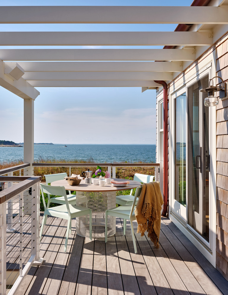 Inspiration for a mid-sized beach style side yard and ground level deck in Boston with a pergola and cable railing.