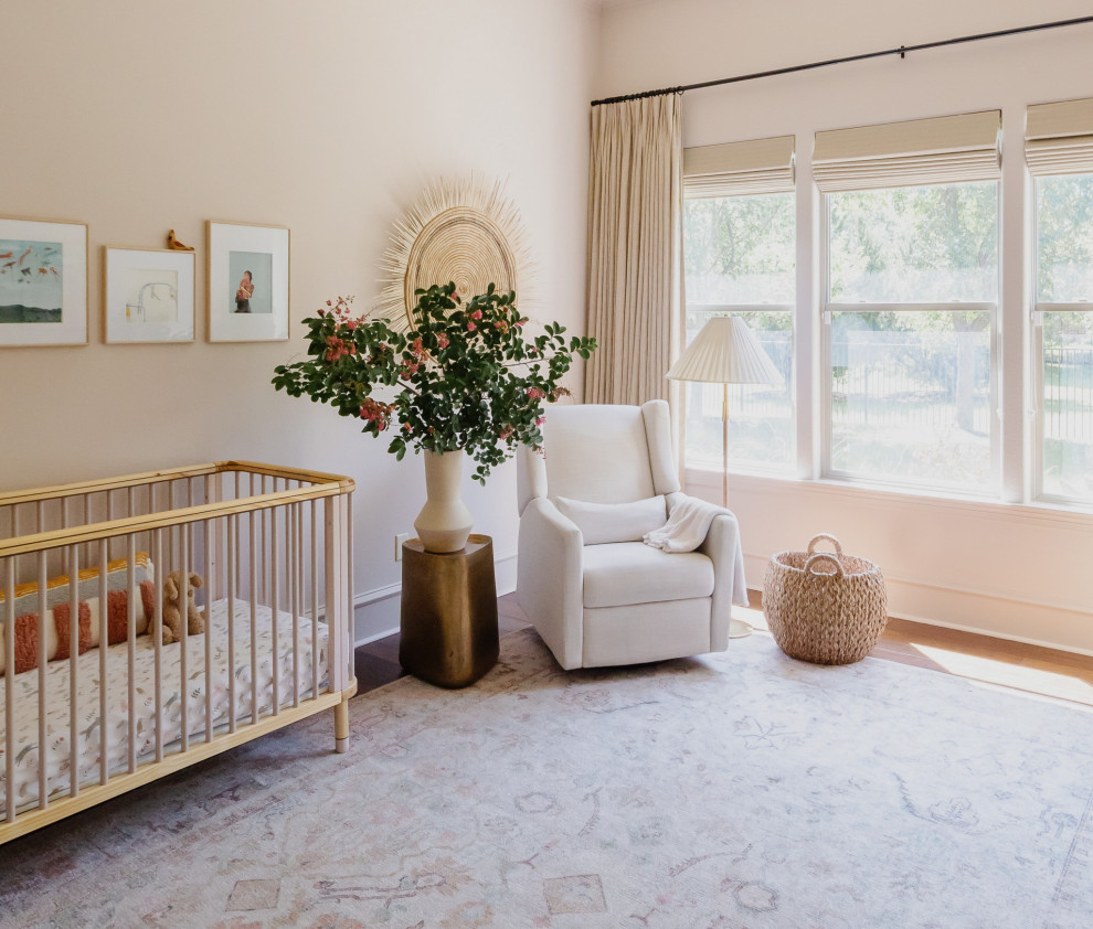Ejemplo de habitación de bebé niña minimalista de tamaño medio con paredes rosas, suelo de madera oscura y suelo marrón