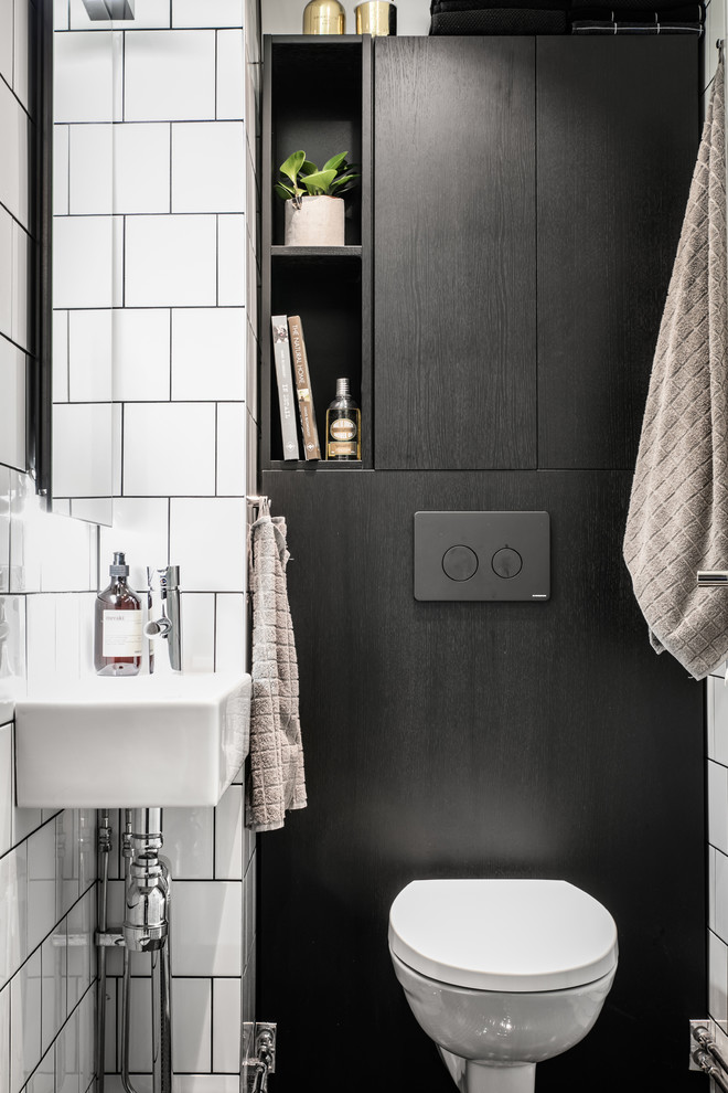 Design ideas for a small scandinavian powder room in Gothenburg with a two-piece toilet, white tile, ceramic tile, white walls and a wall-mount sink.