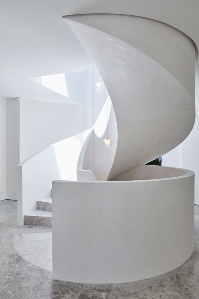 Expansive modern limestone spiral staircase in Melbourne with limestone risers.