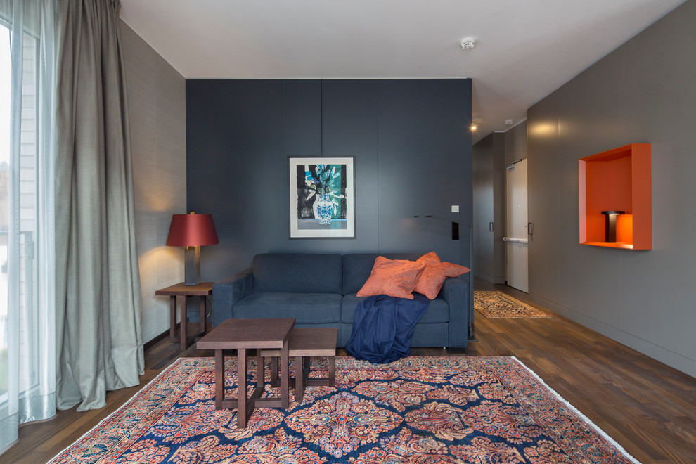 Offenes, Großes Modernes Wohnzimmer mit braunem Holzboden und grauer Wandfarbe in Berlin