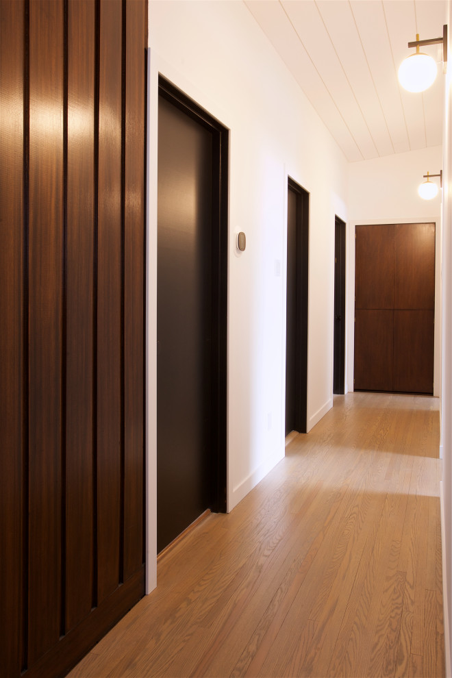1960s light wood floor and shiplap ceiling hallway photo in Other