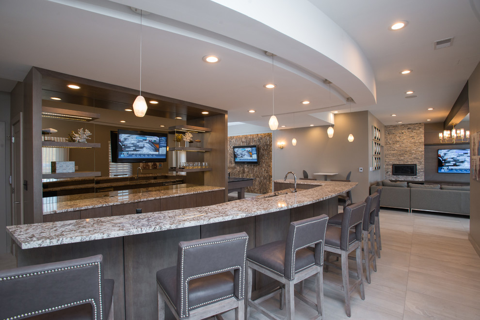 This is an example of a large modern l-shaped seated home bar in Other with an undermount sink, flat-panel cabinets, medium wood cabinets, granite benchtops and beige floor.