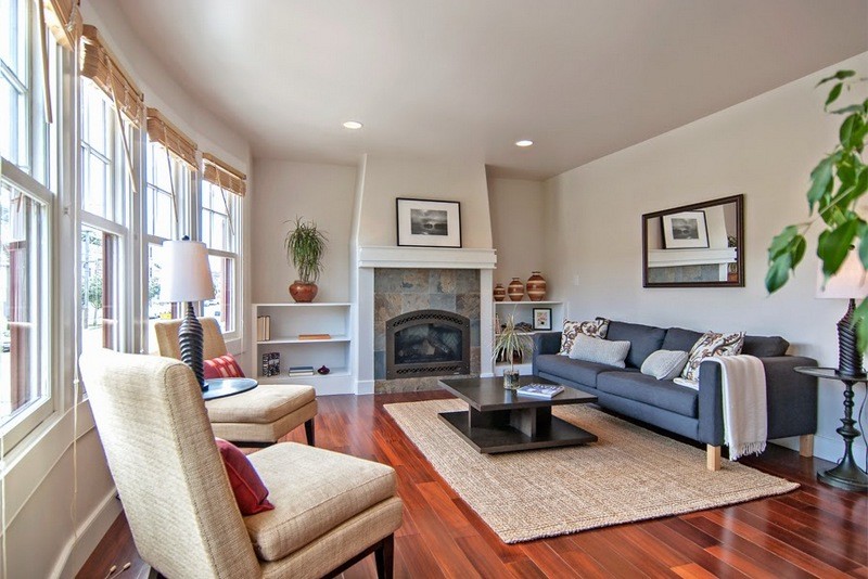 Photo of a mid-sized transitional enclosed living room in San Francisco with a library, no tv, beige walls, dark hardwood floors, a standard fireplace and a tile fireplace surround.