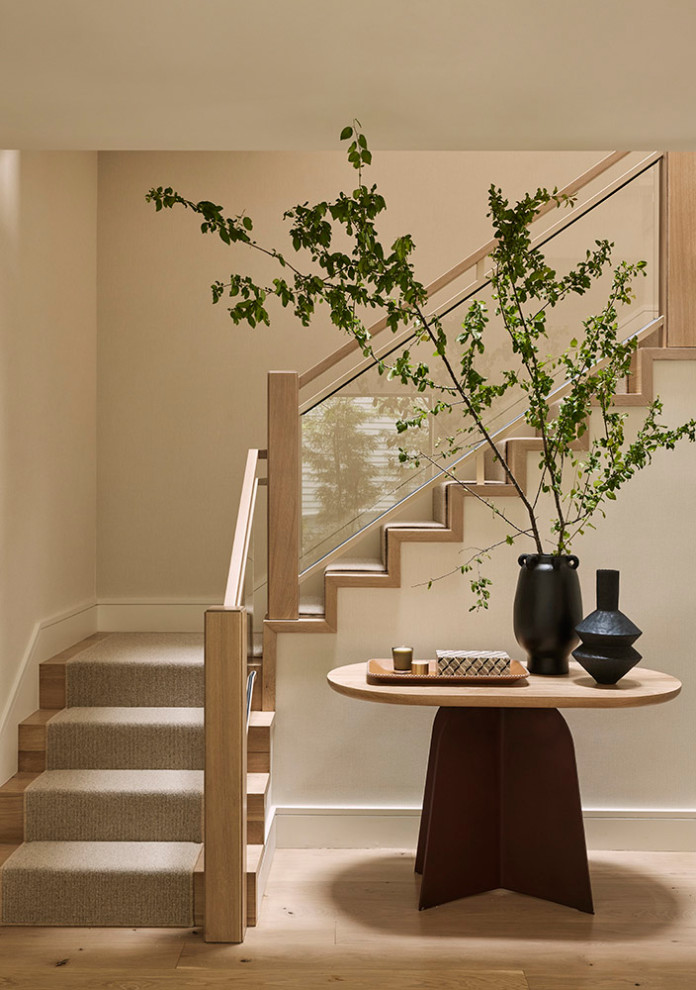 На фото: угловая деревянная лестница среднего размера в современном стиле с деревянными ступенями и стеклянными перилами