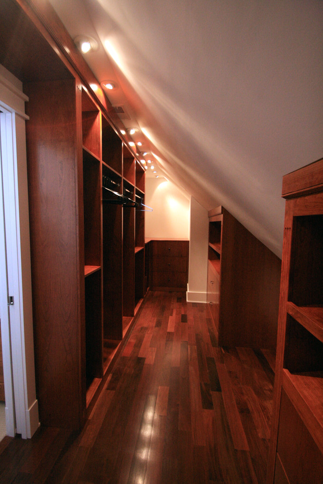Photo of a large traditional gender-neutral walk-in wardrobe in DC Metro with medium wood cabinets and dark hardwood floors.