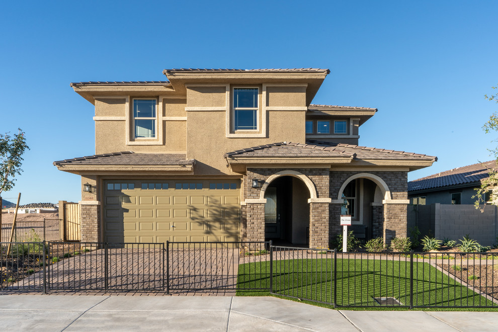 This is an example of a mid-sized transitional two-storey adobe beige house exterior in Phoenix with a gable roof and a shingle roof.