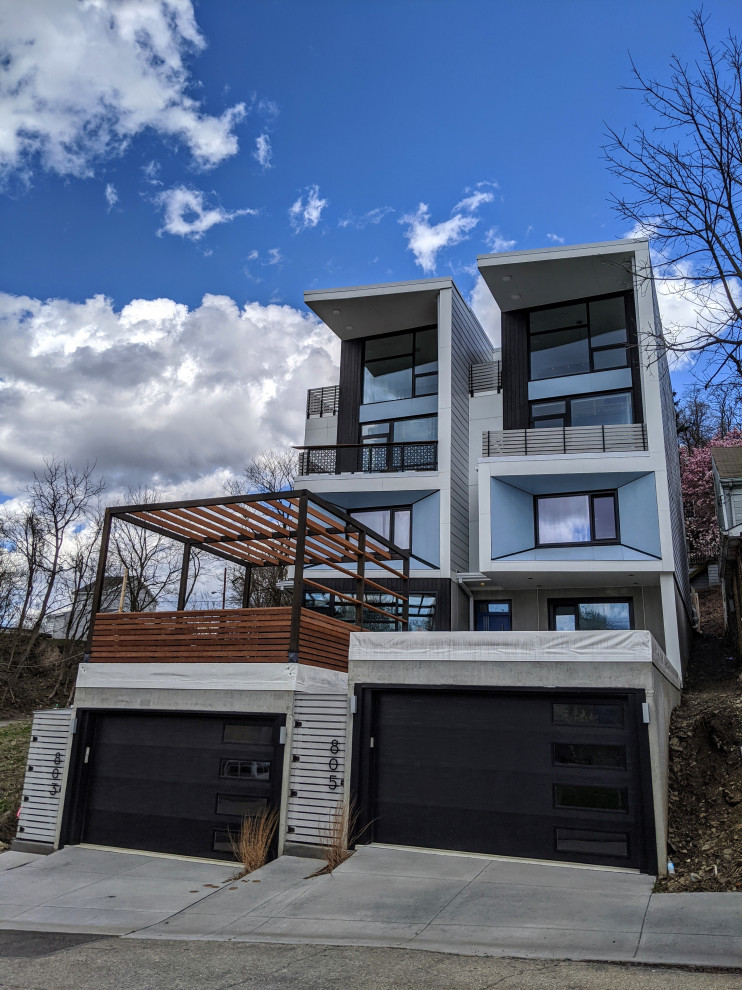 Example of a huge multicolored three-story board and batten flat roof design