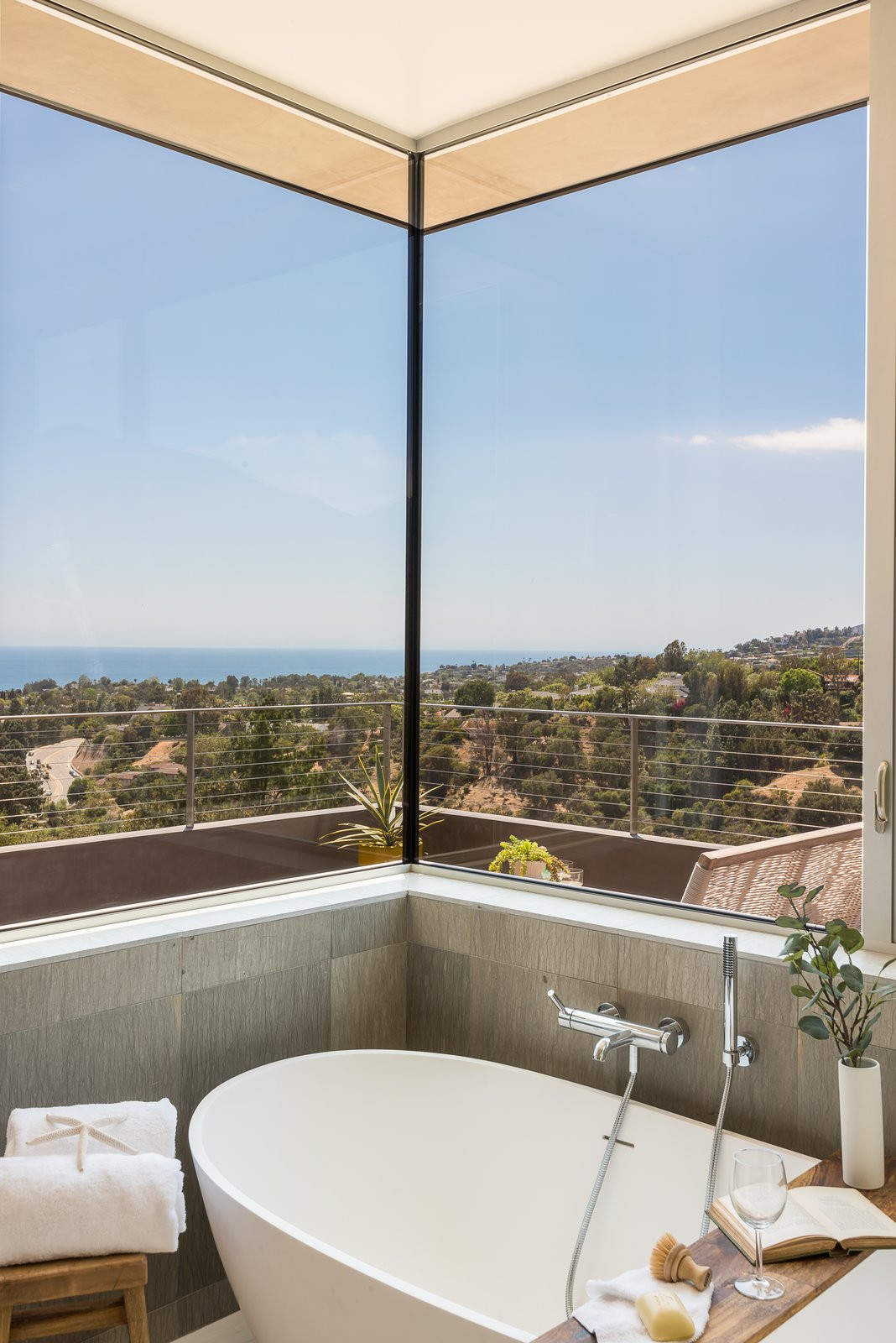 Beach style double-sink freestanding bathtub photo in Los Angeles with light wood cabinets and white countertops