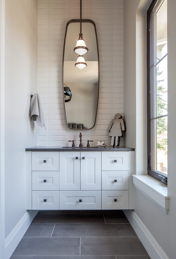 This is an example of a small country kids bathroom in Portland with shaker cabinets, white cabinets, a drop-in tub, a shower/bathtub combo, a one-piece toilet, white tile, porcelain tile, multi-coloured walls, porcelain floors, an undermount sink, engineered quartz benchtops, grey floor and a shower curtain.