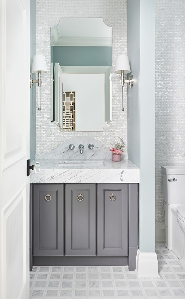 Inspiration for a mid-sized transitional powder room in Toronto with recessed-panel cabinets, grey cabinets, white tile, mosaic tile, grey walls, an undermount sink, grey floor and white benchtops.