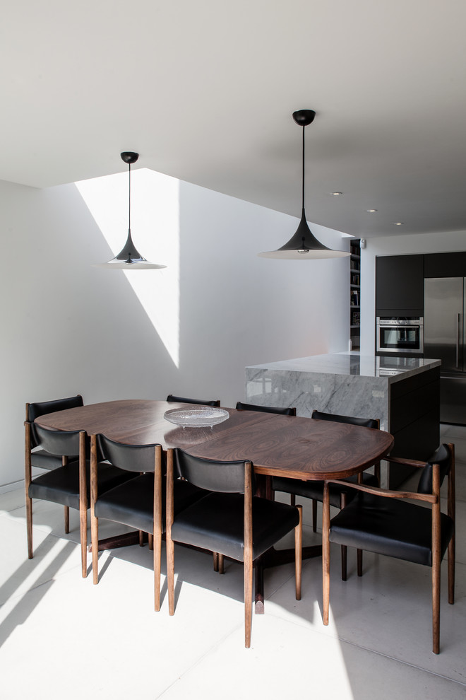 This is an example of a contemporary kitchen/dining combo in London with white walls.
