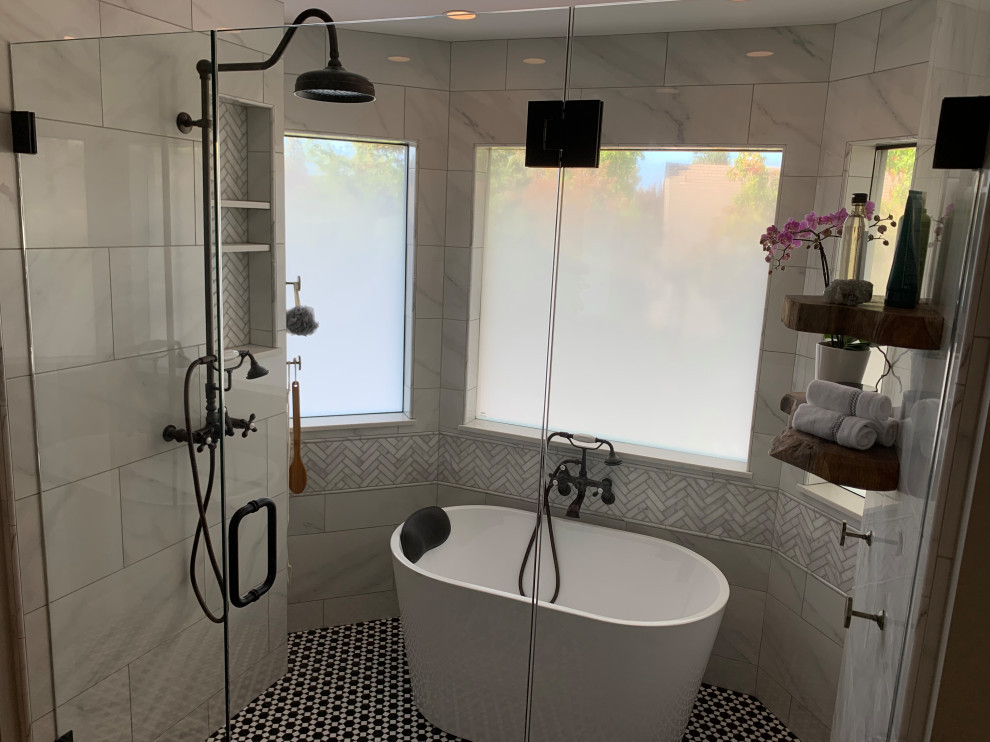 Cette image montre une grande salle de bain principale minimaliste en bois brun avec un placard à porte shaker, une baignoire indépendante, un espace douche bain, un carrelage gris, des carreaux en allumettes, un mur gris, un sol en carrelage de terre cuite, un lavabo encastré, un plan de toilette en marbre, une cabine de douche à porte battante, un plan de toilette blanc, meuble double vasque et meuble-lavabo encastré.