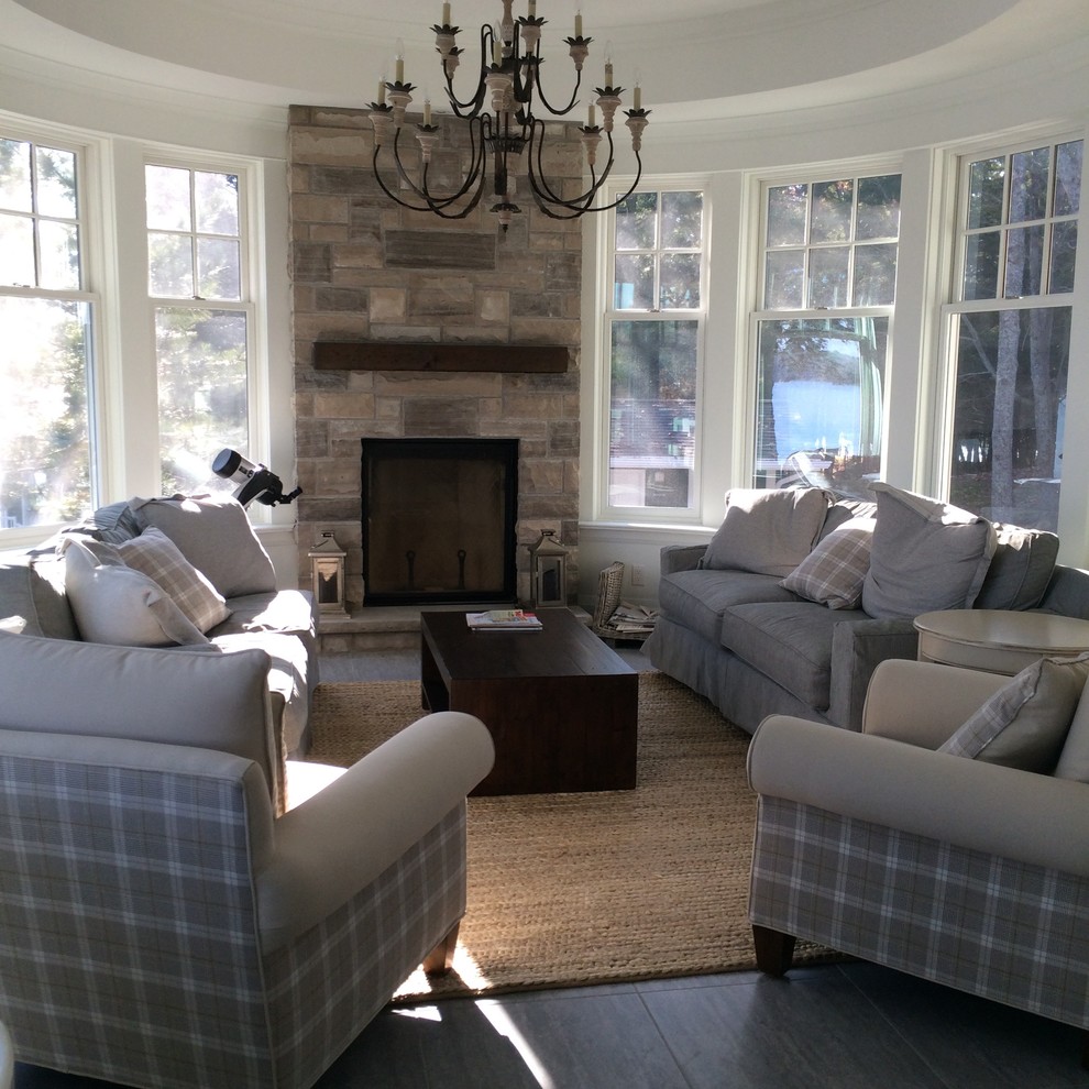 This is an example of a large traditional enclosed family room in Toronto with a library, white walls, dark hardwood floors, a standard fireplace, a stone fireplace surround and no tv.