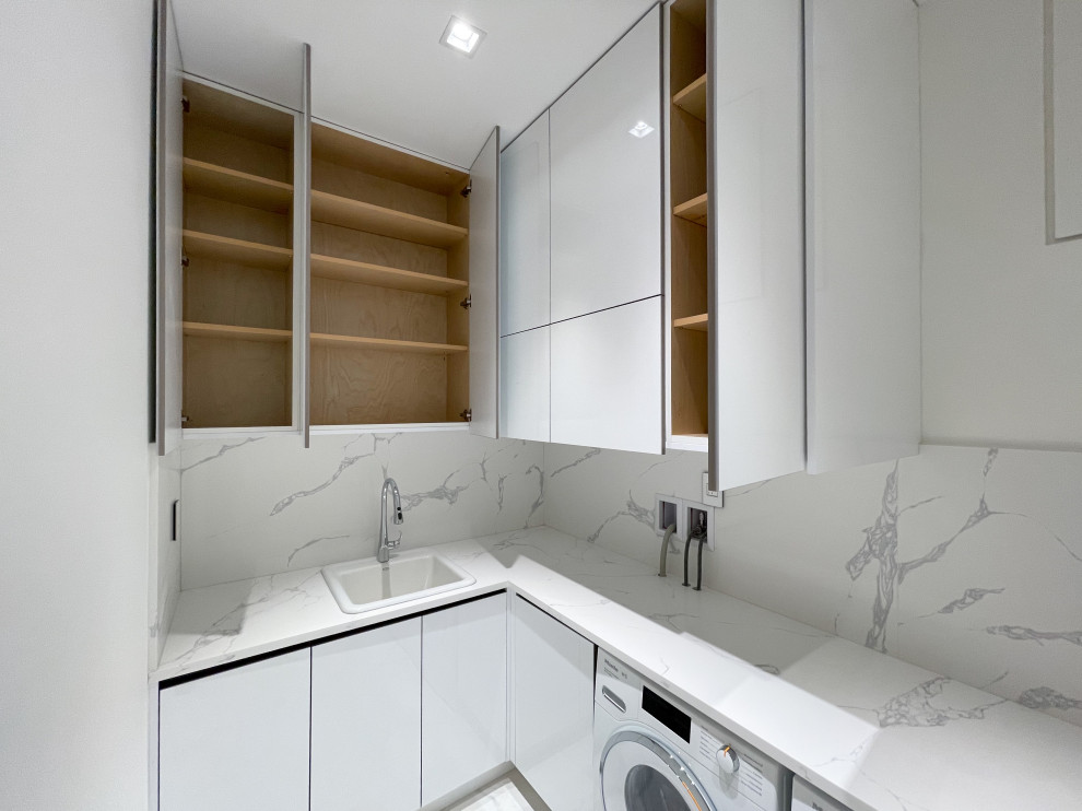 Photo of a mid-sized modern l-shaped dedicated laundry room in Vancouver with open cabinets and white cabinets.