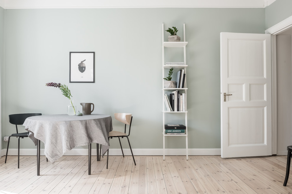 Modelo de comedor escandinavo de tamaño medio abierto con paredes verdes y suelo de madera clara