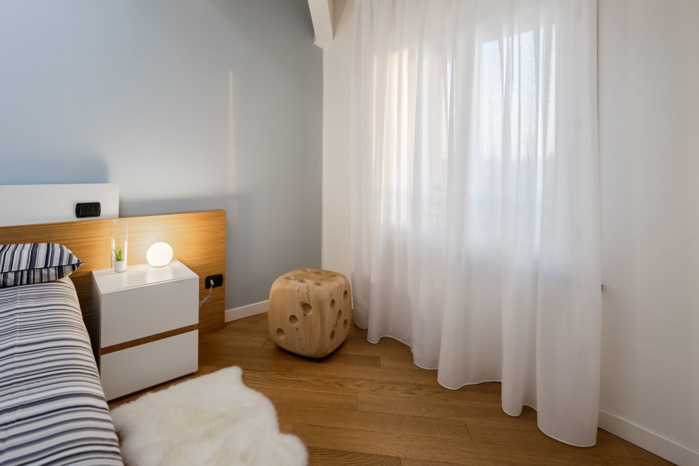 Modelo de dormitorio principal escandinavo grande con paredes multicolor, suelo de madera clara, suelo beige y vigas vistas