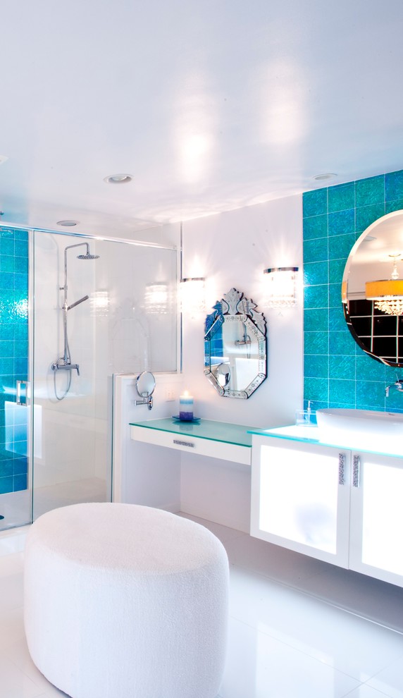 Photo of a large contemporary master bathroom in New York with glass-front cabinets, white cabinets, a corner shower, blue tile, glass tile, white walls, a drop-in sink and glass benchtops.