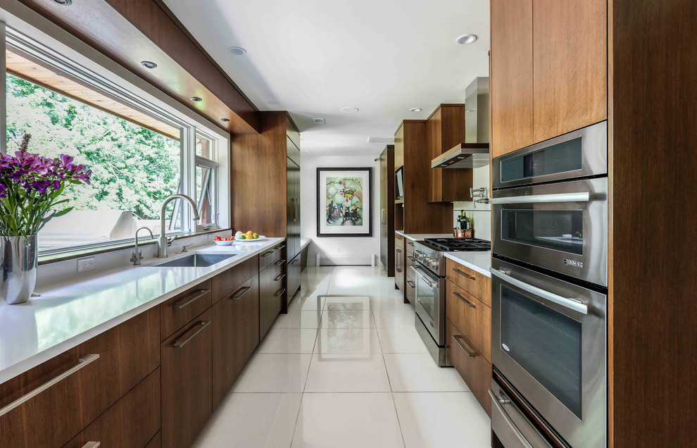 Design ideas for a large modern galley separate kitchen in Denver with an undermount sink, flat-panel cabinets, brown cabinets, stainless steel appliances, porcelain floors, white floor and white benchtop.