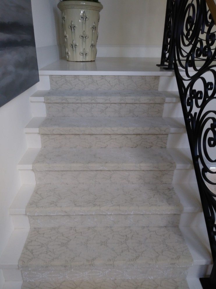 Photo of a large contemporary marble l-shaped staircase in Miami with marble risers and metal railing.