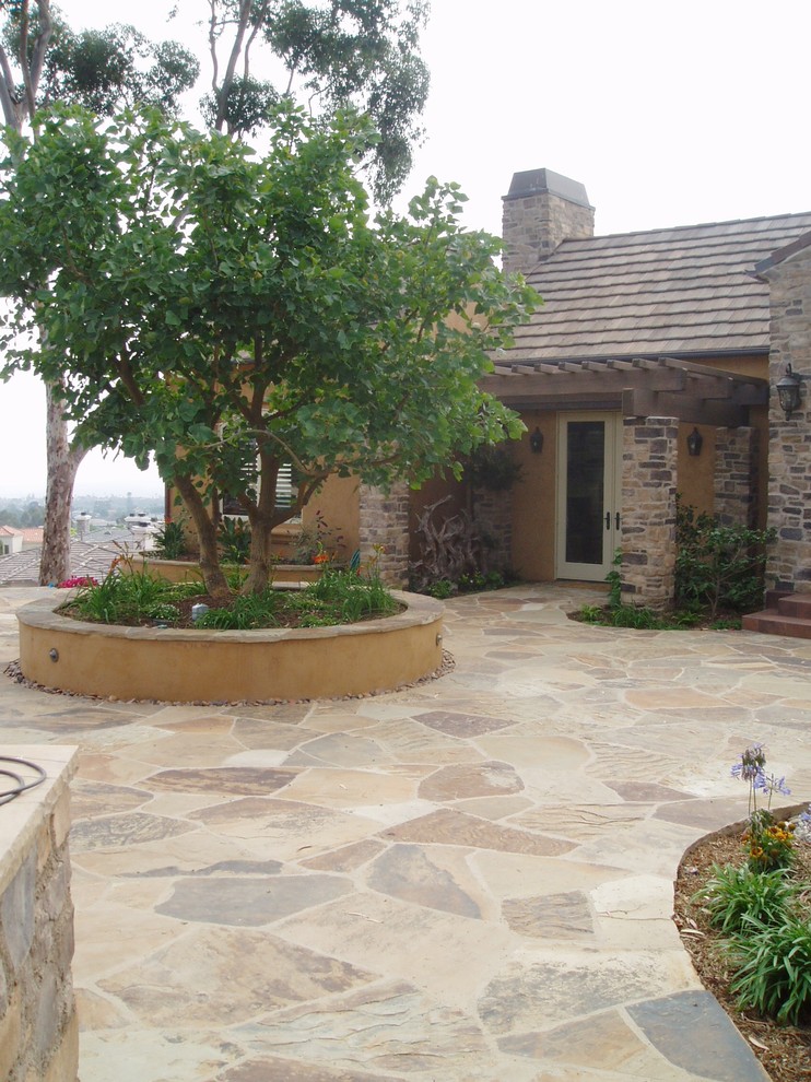 Photo of a mediterranean patio in San Diego with natural stone pavers.