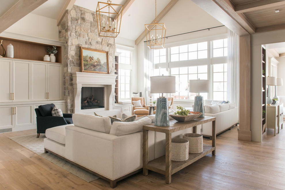 Design ideas for a large traditional formal enclosed living room in Salt Lake City with white walls, light hardwood floors, a standard fireplace, a stone fireplace surround, no tv and beige floor.