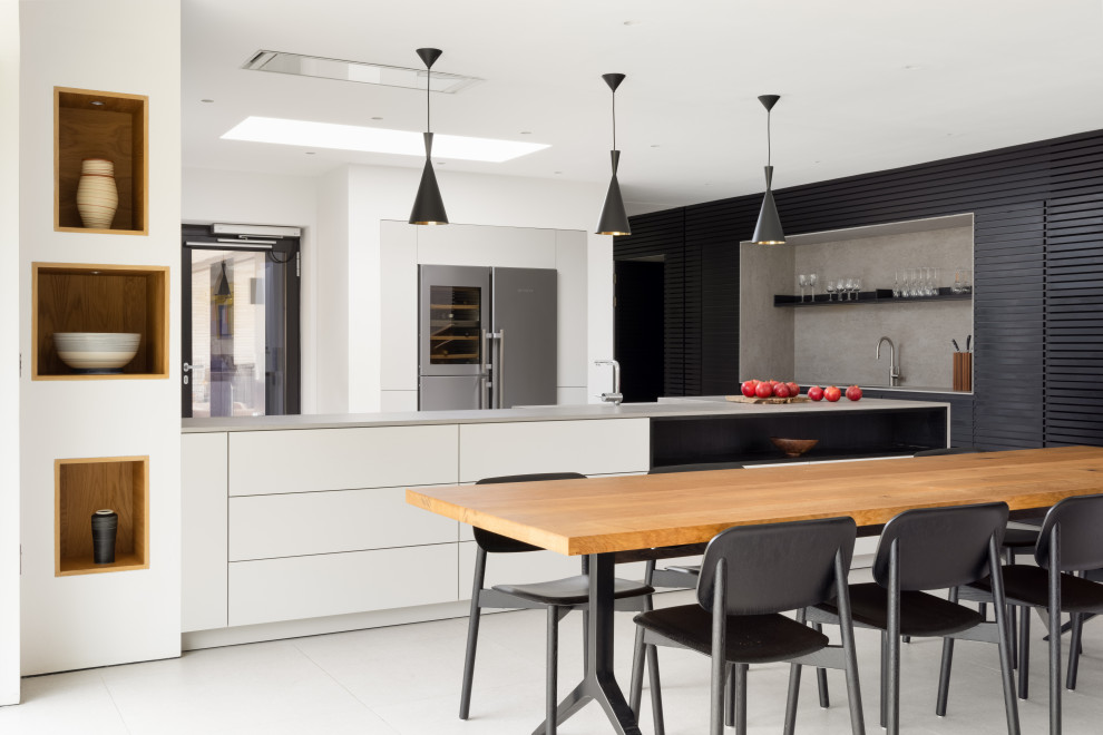 Photo of a large contemporary eat-in kitchen in Hampshire with flat-panel cabinets and with island.
