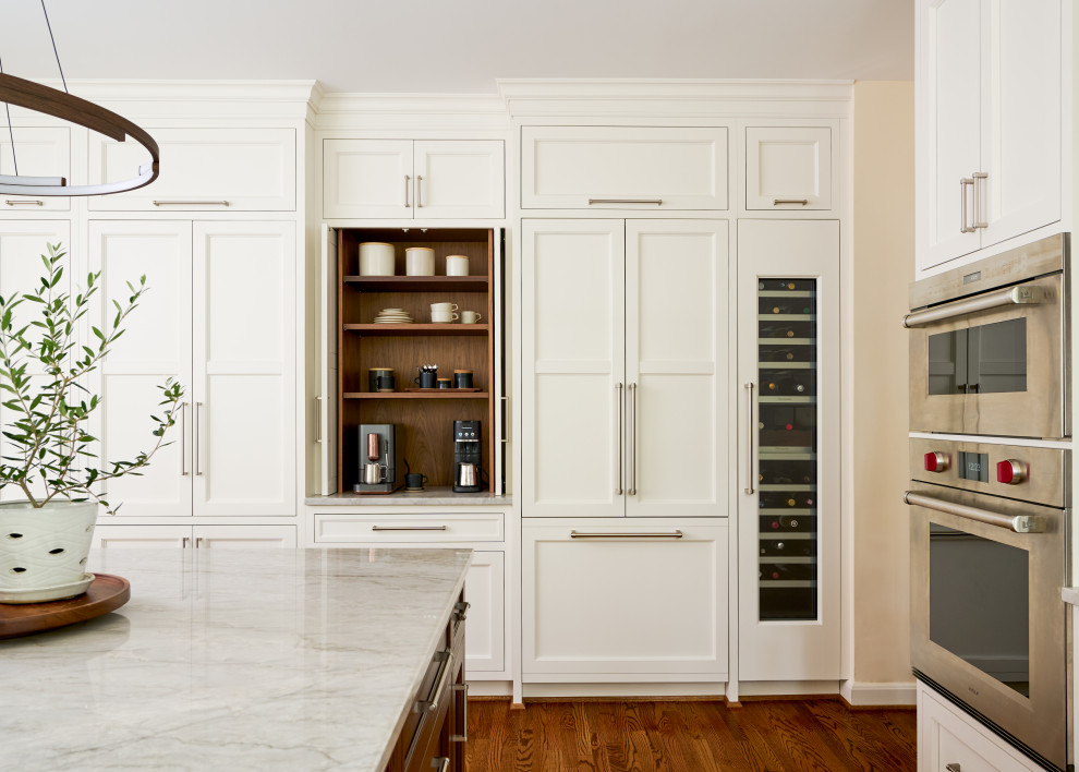 Mid-sized transitional u-shaped medium tone wood floor and brown floor open concept kitchen photo in DC Metro with an undermount sink, recessed-panel cabinets, white cabinets, marble countertops, multicolored backsplash, marble backsplash, paneled appliances, an island and multicolored countertops