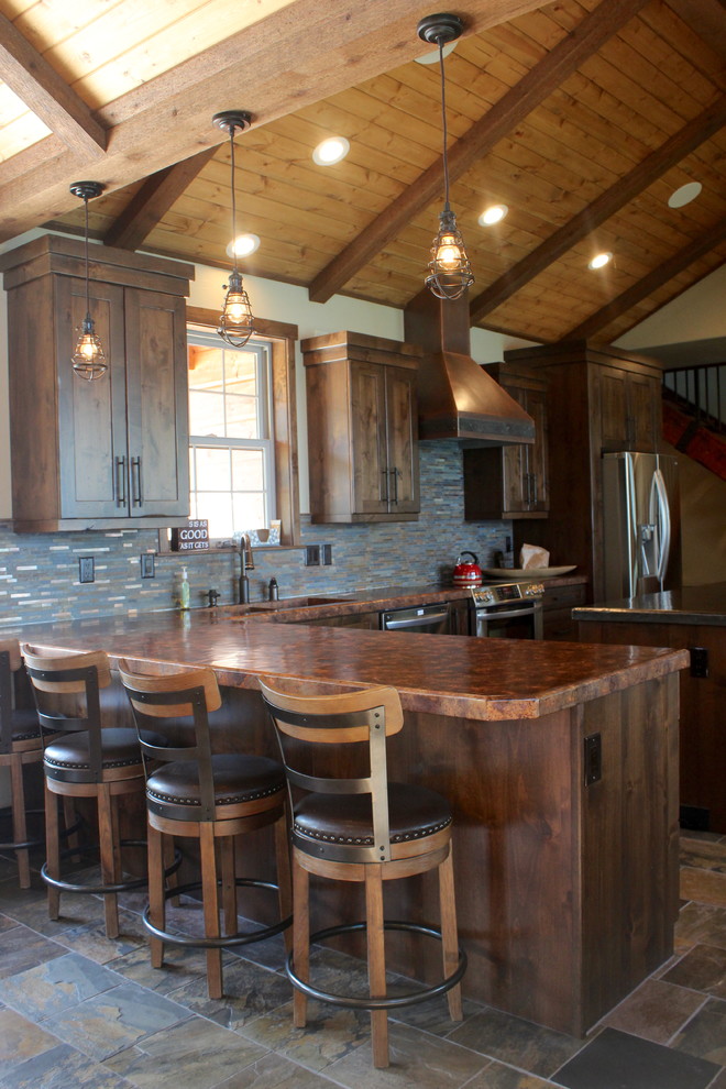 Large transitional l-shaped medium tone wood floor and multicolored floor eat-in kitchen photo with an undermount sink, shaker cabinets, dark wood cabinets, granite countertops, beige backsplash, stone tile backsplash, stainless steel appliances and an island