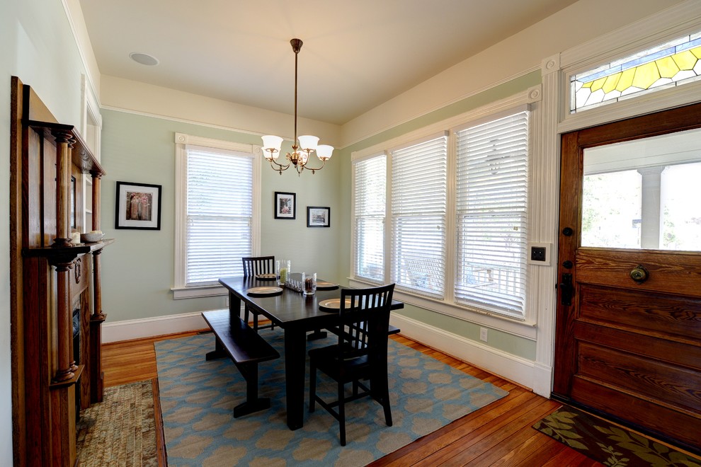 Traditional dining room in Atlanta with green walls and dark hardwood floors.
