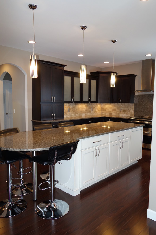 Mid-sized transitional u-shaped dark wood floor eat-in kitchen photo with an undermount sink, recessed-panel cabinets, dark wood cabinets, quartzite countertops, beige backsplash, stone tile backsplash, stainless steel appliances, gray walls and an island