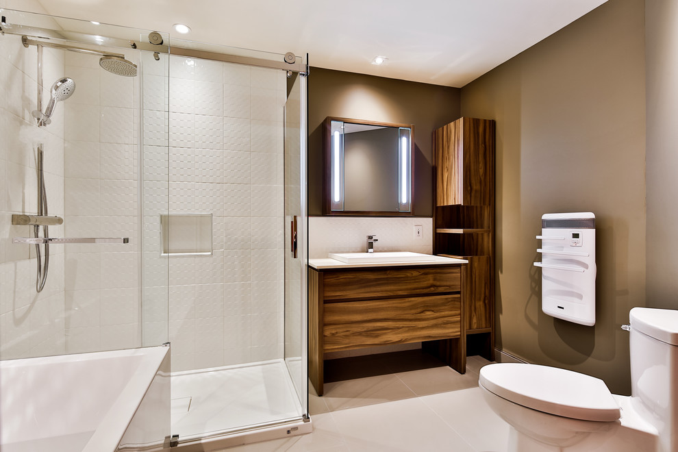 Inspiration for a mid-sized contemporary master bathroom in Montreal with a vessel sink, furniture-like cabinets, medium wood cabinets, glass benchtops, a shower/bathtub combo, a two-piece toilet, white tile, ceramic tile, grey walls and porcelain floors.